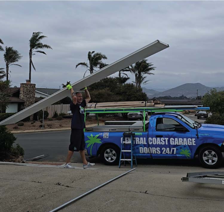 owner of central coast garage doors 24/7 carrying a new garage door to replace